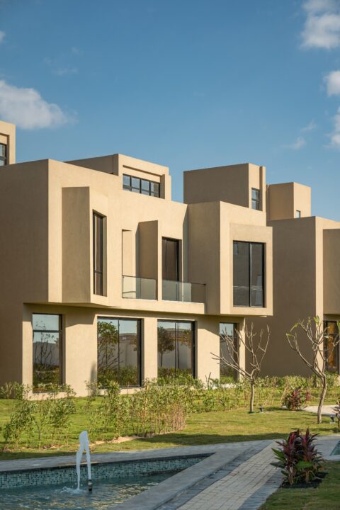 Luxury modern villas at sunset with glass balconies, minimalist design, and warm architectural lighting